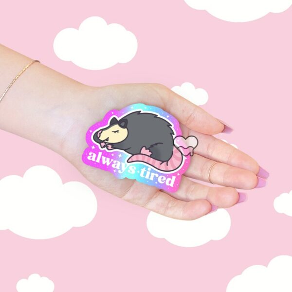 A graphic of Always Tired Possum Sticker available on HeckinMagical.com