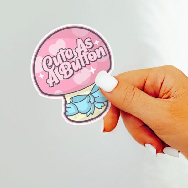 A graphic of Cute As A Button Sticker available on HeckinMagical.com