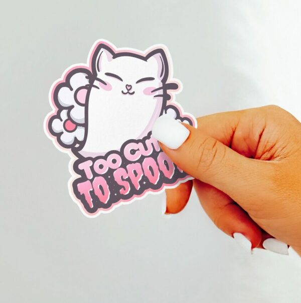 A graphic of Too Cute To Spook Cat Ghost Sticker available on HeckinMagical.com